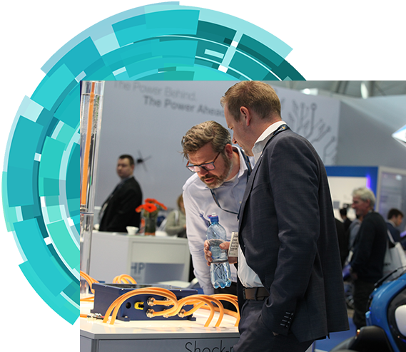 Two men examining a display of electric cars, showcasing modern automotive technology and sustainable transportation options